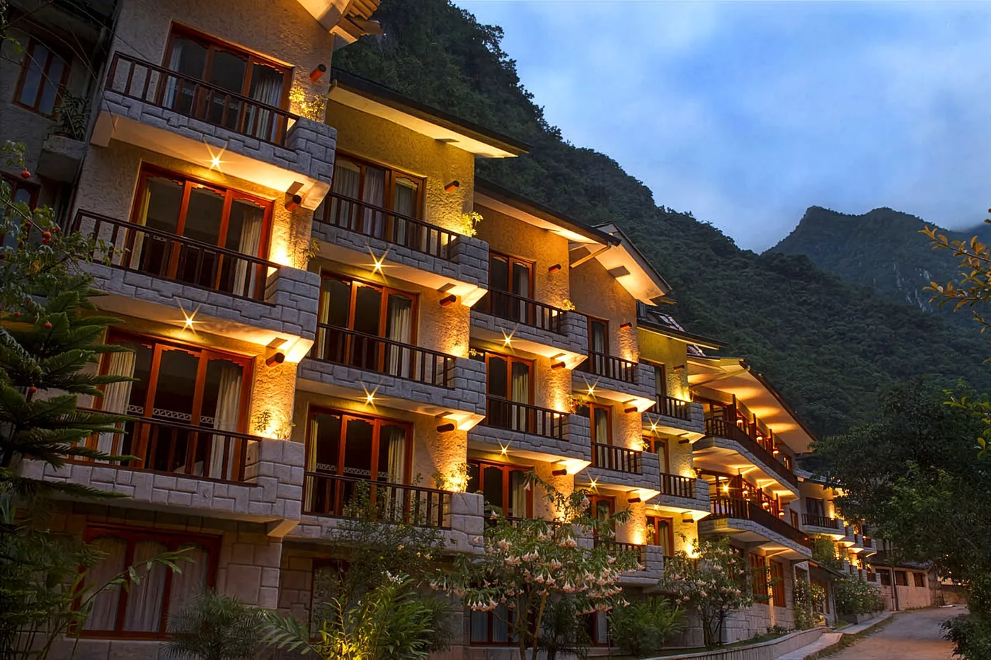 Fachada del Sumaq Hotel iluminada al anochecer en Machu Picchu Pueblo